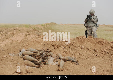Stati Uniti Army Spc. Joel LeMaistre, un soldato assegnato al Comune di combattere Camera-Iraq, documenti riprese video di una cache di armi scoperto vicino a K-3, Iraq, 13 aprile. Il team EOD è venuto a far esplodere una cache di più di 30 120-mm russo colpi di mortaio il Golden Lions del combinato di forza di sicurezza scoperto durante una ricerca nella cache. Foto Stock