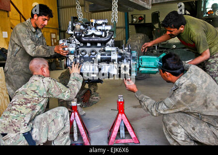 Stati Uniti Esercito Pvt. Rodger Pendergrass e l esercito nazionale afghano soldati riparare un motore in occasione del pool in avanti su una base operativa Airborne sett. 4, 2012, nella provincia di Wardak, Afghanistan. Pendergrass è assegnato al 4° Battaglione, campo 319reggimento di artiglieria, 173rd Airborne Brigade Combat Team. Stati Uniti Army Spc. Alexandra Campo Foto Stock