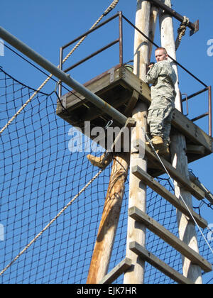 Stati Uniti Esercito candidato ufficiale di Alan Babcock dal Bravo Company, 3° Battailon, undicesimo Reggimento di Fanteria guarda giù come egli raggiunge la sommità di un ostacolo sul Bolton corso di fiducia a Fort Benning, Ga., Marzo 13, 2008. Soldati con la società sono nella loro prima settimana di Officer scuola del candidato. Kenneth R. Toole Foto Stock