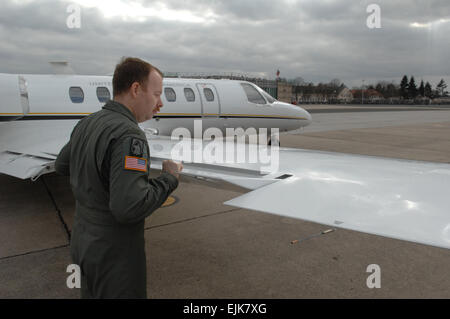 Stati Uniti Army Chief Warrant Officer 5 Mark Gaston, da Fox Company, 52nd reggimento di aviazione, conduce un controllo di preflight di un alettone su un UC-35 aeromobili a Wiesbaden Army Airfield, Germania, 17 marzo 2008. Mark L. Warren Foto Stock