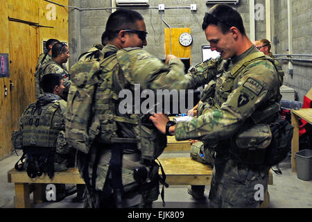 Stati Uniti Esercito nazionale Guard Spc. Nicholas Cerreto destra, una forza di sicurezza membro del Team di Ricostruzione Provinciale Farah, aiuta un compagno soldato a prepararsi per una missione a Farah City a inoltrare una base operativa Farah, provincia di Farah, Afghanistan, il Agosto 29. PRT Farah è un gruppo di soldati, marinai e aviatori collaborando con vari enti pubblici e non le agenzie del governo con il compito di facilitare la governance e la stabilità nella regione da lavorare mano nella mano con i funzionari locali e il governo della Repubblica islamica dell'Afghanistan. L'obiettivo del PRT è quello di promuovere il governo afghano e i loro abili Foto Stock