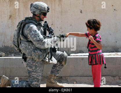 Il personale Sgt. Richard Grimsley, di Charleston S.C., saluta una giovane ragazza irachena durante un checkpoint patrol, 19 agosto 2009, in la Ma'dain regione situata al di fuori di Bagdad orientale. Grimsley è un leader di squadra assegnato a una truppa, 5° Stormo, 73rd reggimento di cavalleria, 3° Brigata Team di combattimento, ottantaduesima Airborne Division, Divisione multinazionale - Bagdad. Prima di passare alla periferia orientale di Baghdad, truppa a azionati nel cuore di Baghdad Rusafa del distretto. Pvt. Jared N. Gehmann Foto Stock