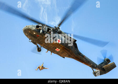 Un U.S. Esercito UH-60 Black Hawk elicottero montacarichi un australiano airman durante medevac formazione su base multinazionale Oggi Tarin Kot in Afghanistan la provincia di Uruzgan, 13 ottobre, 2013. L'elicottero equipaggio è assegnato alla società C, 2° Battaglione, 1° supporto generale del battaglione di aviazione. Australian Defence Force foto di Cpl. Mark Doran Foto Stock