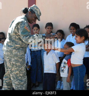 Stati Uniti Il personale dell'esercito Sgt. Tracey Francesco, team medic per Joint Task Force-Bravo civile operazioni militari, gioca con i bambini a Carlos Sanchez School di La Paz, Honduras, Feb 21, 2008. JTF-Bravo servizio assistito i membri rappresentanti di dare un bambino uno zaino distribuire oltre 700 zaini per la scuola dei bambini in Honduras. Tech. Sgt. John Asselin rilasciato Foto Stock