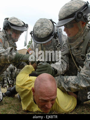 Stati Uniti I soldati dell esercito dal 130Polizia Militare Company, Tennessee Army National Guard per detenere un istruttore role-playing come rioter durante la formazione a Muscatatuck urbano del centro di formazione, Ind. Agosto 25, 2007. I soldati sono la formazione in preparazione di un imminente distribuzione per il Kosovo. Spc. Girolamo Vescovo, Foto Stock