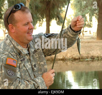 Cappellano Capt. Bruce Wagner, il 115Brigata Battaglione supporto cappellano di Copeland, Ala. bobine nella sua prima cattura del giorno presso il laghetto dove ha regolarmente i pesci a Camp Taji, Iraq. Spc. Shejal Pulivarti, 1° BCT, 1° Cav. Div. Affari pubblici Foto Stock