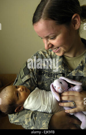 Stati Uniti Army Spc. Stephanie Defreest detiene il 22-giorno-vecchio figlio durante una comunità medica programma di outreach in Yarmuk, Iraq, Sett. 5, 2007. Defreest è un combattimento medic assegnato alla società di Charlie, 299i Forward Support Battaglione, 2° Brigata Team di combattimento, 1° Divisione di Fanteria, basato fuori di Schweinfurt, Germania. Tech. Sgt. Andrew M. Rodier, Foto Stock