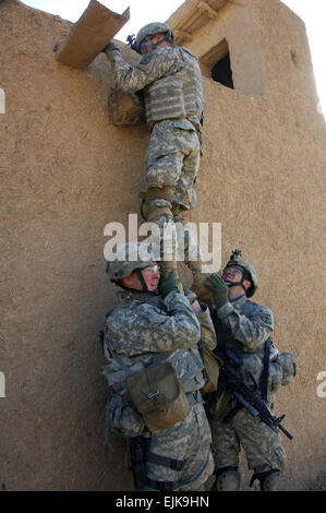 Stati Uniti Pfc dell'esercito. Ryan Mahan e SPC. Stephen McLain paranco PFC. Ryan Springstead come egli si affaccia su una parete per vedere se sono in grado di entrare in una casa attraverso il tetto di un edificio in Chinchal, Iraq, a gennaio 8, 2008. I soldati sono assegnati al 3° plotone, Alfa truppa, 1° Stormo, 71st reggimento di cavalleria, 1° Brigata Team di combattimento, decimo Montagna divisione. Spc. Laura M. Buchta, U.S. Esercito. Foto Stock