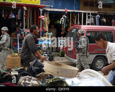 Stati Uniti I soldati dell esercito con la quarta brigata Team di combattimento, terza divisione di fanteria e i cittadini iracheni a piedi attraverso il marketplace in Musayyib, Iraq, Marzo 11, 2008. I soldati pattugliano la zona per monitorare iracheno recente crescita economica. Spc. Angelica Golindano rilasciato Foto Stock