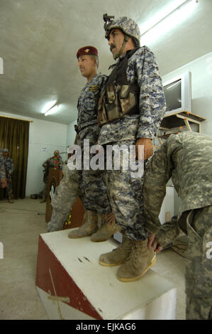 Iracheno di polizia nazionali ricevere U.S. Cavalleria speroni di combattimento durante una cerimonia di premiazione presso la sede dell'Iraqi National Police 3° Battaglione in Jasr Diyala, Iraq, 14 aprile 2008. Stati Uniti I soldati dell esercito dal 3° Stormo, 1° reggimento di cavalleria, 3° Brigata Team di combattimento, terza divisione di fanteria ha condotto la cerimonia. Pfc. David J. Marshall rilasciato Foto Stock