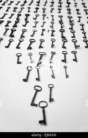 Vecchie chiavi arrugginite appeso a una parete bianca da chiodi, Caceres, Spagna Foto Stock