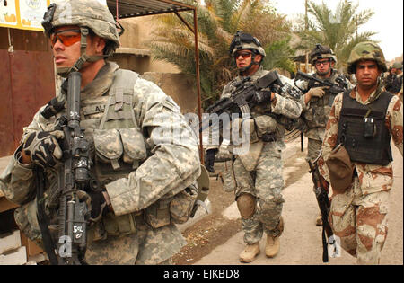 Da sinistra, U.S. Il personale dell'esercito Sgt. Juan Alba, Cpl. Giuseppe Casiano, SPC. David Tunstall e un iracheno National Police officer condurre un combinato di cordon e ricerca di pattuglia del piede in un mercato di Ghazaliya, Iraq, Marzo 23, 2007. I soldati sono da Black Hawk Company, 1° Battaglione, XXIII Reggimento di Fanteria, 3° Brigata Team di combattimento, seconda divisione di fanteria. Sgt. Tierney Nowland, U.S. Esercito. Foto Stock