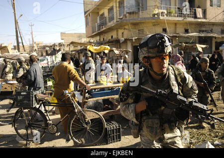 Stati Uniti Army Spc. Kon Im e la sua squadra si muovono attraverso un mercato all'aperto durante un piede pattuglia in Baqubah, Iraq, Aprile 5, 2007. I soldati sono con il 5° Battaglione, ventesimo reggimento di fanteria. Il personale Sgt. Stacy L. Pearsall, U.S. Air Force. Foto Stock