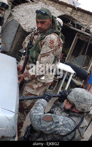 Un esercito iracheno soldato aiuta a U.S. Il personale dell'esercito Sgt. Jeremy Rausch aprire un baule auto durante una ricerca per veicolo sospetto a carico ordigni esplosivi artigianali in Adhamiya, Iraq, Aprile 9, 2007. Rausch è con Charlie Company, 1° Battaglione, XXVI Reggimento di Fanteria, 1a divisione di fanteria. Sgt. Jeffrey Alexander Foto Stock