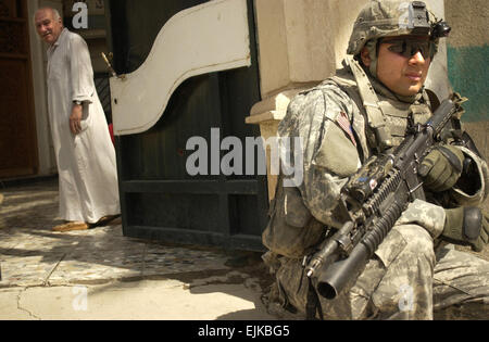 Stati Uniti Army Sgt. Luis crociera sicurezza tira fuori una casa durante un combinato di cordon e cerca con l'esercito iracheno in Ameriyah, Iraq, 25 aprile 2007. Crociera è assegnato a Charlie Company, 1° Battaglione, XXIII Reggimento di Fanteria, 3° Stryker Brigade Combat Team, seconda divisione di fanteria. Sgt. Tierney Nowland Foto Stock