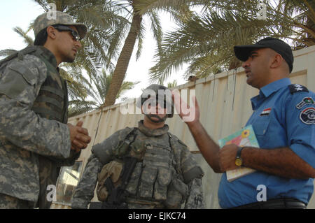 Stati Uniti Army Sgt. William Gorton, dal 2 Squad, primo plotone, XXIII Polizia Militare Company, 89La Polizia Militare brigata, Fort Bragg, N.C., e la sua interprete irachena discutere programmi di allenamento con la sua polizia irachena di contropartita in avanti nei pressi di una base operativa Mahmudiyah, Iraq, 30 maggio 2007. Master Sgt. Jonathan doti Foto Stock