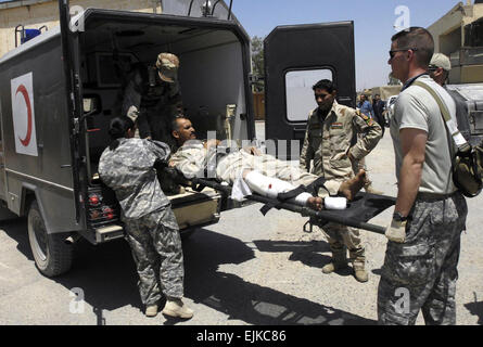 Stati Uniti Esercito Spcs. Cecilia Morales e Lisa Dueker sollevare un soldato iracheno ferito da colpo di pistola Giugno 6, 2007 in Mahmudiyah, Iraq. Morales e Dueker sono assegnati a Charlie Company, 2° Battaglione, decimo brigata battaglione di supporto, 2° Brigata Team di combattimento, decimo Montagna divisione, Fort Drum, N.Y., e HHB, 2° Battaglione, xv campo artiglieria, 2° Brigata Team di combattimento, decimo Montagna divisione, Fort tamburo, N.Y. Il personale Sgt. Dennis J. Henry Jr. Foto Stock