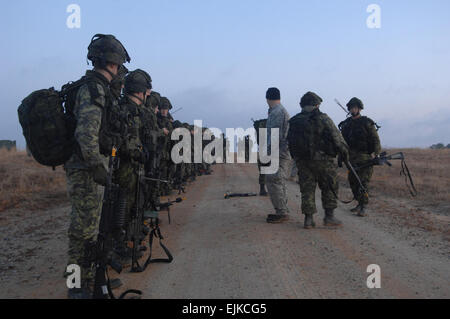 Esercito canadese soldati dal West Nova Scotia Regiment e U.S. I soldati dell esercito da Alfa Co., 3° Battaglione, 3a delle forze speciali Gruppo Airborne attendere l'arrivo del loro elicottero durante l'esercizio Southbound Trooper IX a Fort Pickett, Va. Feb 19, 2009. Spc. Kurt Lamel Foto Stock