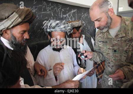 Lt. Col. Mark Reynolds aiuta a testare un locale uomo afgano della visione con una acutezza visiva grafico durante un villaggio medica Programma di Outreach nella provincia di Herat, Afghanistan, Sett. 27, 2011. Il programma è stato condotto per rendere economico bicchieri a disposizione per gli uomini, le donne e i bambini della scuola nel villaggio. Foto Stock