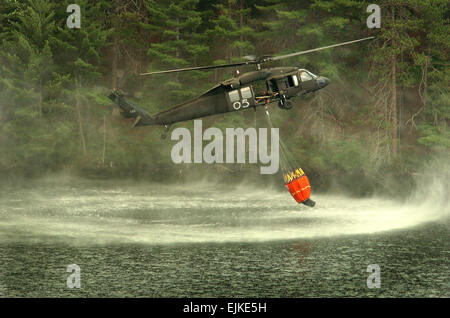 Un esercito di Michigan Guardia Nazionale UH-60 Black Hawk cali di elicottero un Bambi Bucket in un lago di acqua a combattere un incendio vicino Tahquamenon Falls State Park, Mich su Agosto 8, 2007. Il personale Sgt. Helen Miller, U.S. Esercito. Foto Stock