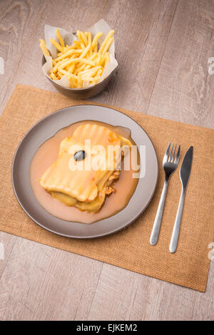 Francesinha e patatine fritte, cibo tipico da Porto, Portogallo Foto Stock