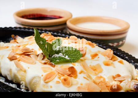 La torta di mele nella glassa alla vaniglia con panna acida e marmellata di ciliege Foto Stock