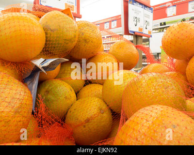 Pila di sacchi di arance in un supermercato espositore. Foto Stock