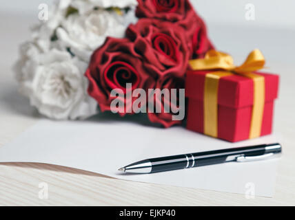 Il messaggio di saluto della scheda in bianco con fiori e regali Foto Stock