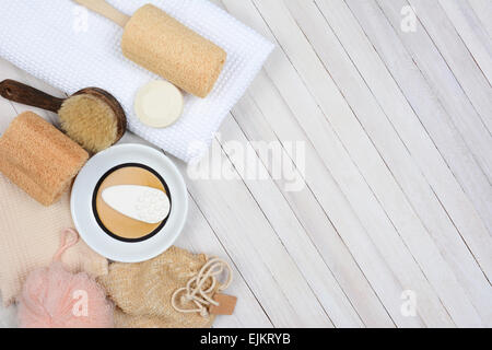 Bagno e Spa ancora in vita. Alta angolazione degli accessori per il bagno tra cui, asciugamani, sapone, loofah e sandali, su un rustico bianco Foto Stock