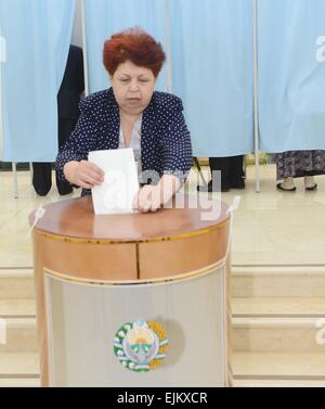 Tashkent, Uzbekistan. 29 Mar, 2015. Una donna getta il suo voto al n. 76 stazione di polling a Tashkent, capitale dell'Uzbekistan, il 29 marzo 2015. Il voto per le elezioni presidenziali dell Uzbekistan ha iniziato domenica. Secondo la Commissione elettorale centrale, oltre 20 milioni di elettori registrati avrebbe gettato i loro voti a oltre 9000 stazioni di polling impostato in tutti i 14 distretti amministrativi di Uzbekistan, come pure nei paesi esteri. © Sadat/Xinhua/Alamy Live News Foto Stock