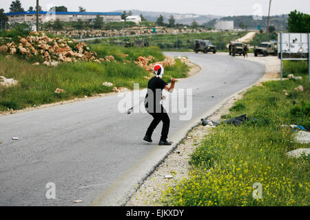 La Palestina. 28 Mar, 2015. Un dimostrante palestinese si prepara a scagliare una pietra verso le truppe israeliane durante una manifestazione di protesta per la marcatura terra giorno, in Cisgiordania villaggio di Nabi Saleh vicino a Ramallah, Sabato, 28 marzo 2015. Terra giorno commemora sommosse del 30 marzo 1976, quando sei arabi israeliani sono stati uccisi da agenti di sicurezza durante una protesta al governo israeliano la terra gli espropri politiche. Credito: Muhesen Amren/Pacific Press/Alamy Live News Foto Stock