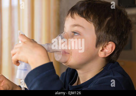 Bambino prendendo le vie respiratorie, la terapia di inalazione Foto Stock