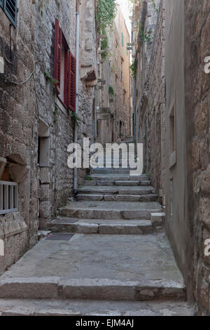 Passaggi e vicolo medievale tra case in pietra che conduce fino alla piazza del Duomo, korcula croazia Foto Stock