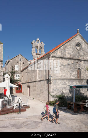 I turisti a piedi nella vecchia città di Korcula passato la Chiesa di Svih Svetih Svi Sveti Tutti i Santi Foto Stock