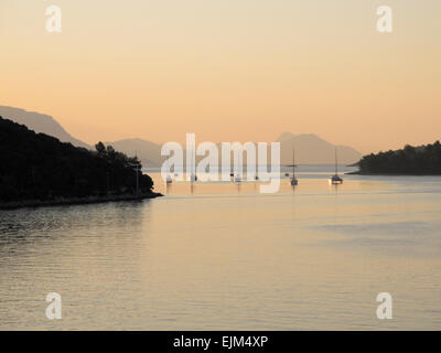 Alba dal traghetto korcula croazia porta la luce del mattino al di sopra del Mare Adriatico con barche ormeggiate Foto Stock