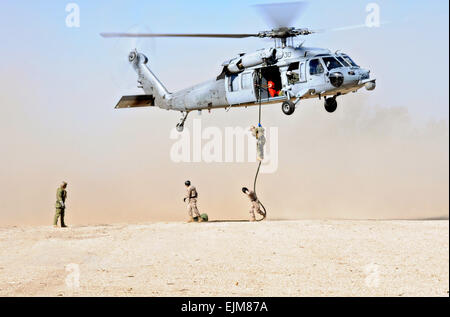 US Navy SEAL i membri del team di l'eliminazione degli ordigni esplosivi unità mobile 8 fast-corda verso il basso un UH-60 Blackhawk elicottero durante la formazione presso la stazione navale di Rota Marzo 6, 2015 in Rota, Spagna. Foto Stock