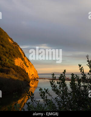 Sunset riflettendo su una roccia in spiaggia Foto Stock