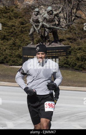 West Point, N.Y, STATI UNITI D'AMERICA. 29 Mar, 2015. KEVIN WILKINS di New Windsor, New York corre fino alla cima di una collina durante la West Point Half-Marathon compagni caduti eseguire presso l'Accademia Militare degli Stati Uniti a West Point, New York. Il monumento ''al soldato americano'' è in background. I nove piedi di statua in bronzo è stata scolpita da Felix de Weldon, che ha anche dato l'Iwo Jima statua presso il Cimitero Nazionale di Arlington. © Tom Bushey/ZUMA filo/Alamy Live News Foto Stock