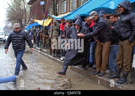 Srinagar Kashmir. 29 marzo, 2015. Un indiano si riserva centrale forza di polizia (CRPF) soldato attraversa una strada saturo di acqua in comercial mozzo di Srinagar la capitale estiva di Indiano Kashmir amministrato su marzo 29,2015 .La valle è stata assistendo a pioggia pesante dal sabato, portando ad una fresca inondazioni panico e improvviso aumento del livello delle acque di fiumi e torrenti e ruscelli attraverso il Kashmir. Credito: NISARGMEDIA/Alamy Live News Foto Stock