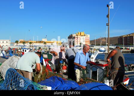 Ordinamento dei pescatori le loro reti da pesca sulla dockside, Puerto de la Atunara, Costa del Sol, la provincia di Cadiz Cadice, Andalusia, Spagna. Foto Stock