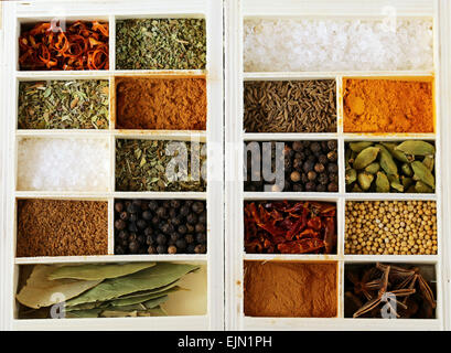 Insieme di tipi diversi di spezie (pepe, sale, curcuma, foglie di alloro, il peperoncino, erbe aromatiche) in una scatola di legno Foto Stock