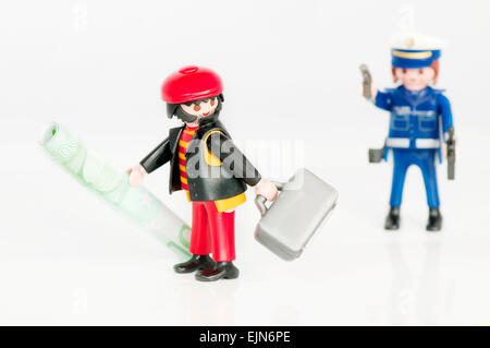 Un poliziotto di Playmobil a caccia di un Bank Robber isolato su bianco. Foto Stock