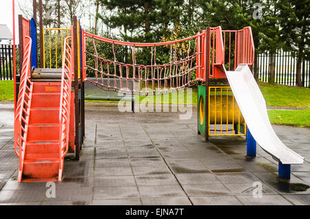 Far scorrere e arrampicata telaio in corrispondenza di un bambini Parco di oscillazione. Foto Stock