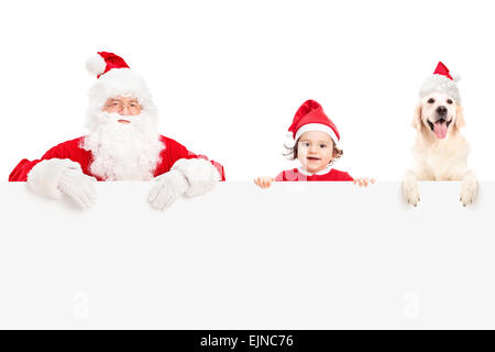 Babbo Natale, un simpatico baby girl e un Labrador retriever cane in posa dietro un cartello bianco isolato su sfondo bianco Foto Stock