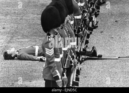 Il Wobblies: sfilando guardie ha gettato un adattamento della wobblies sabato (9-6-79). Il tempo era umido go che non riusciva a piedi la linea durante la prova finale per il Trooping la cerimonia di colore a Londra il sabato (16-6-79). In un momento non custodito, due giovani soldati svenuto. Migliaia di turisti, stipati in sfilata delle Guardie a Cavallo, visto che i due sono stati portati via sulle barelle - e la sottile linea rossa è diventato un po' più sottile. Momento incustodito....è tutto troppo per questa protezione, come egli colpisce il deck. Il 9 giugno 1979 Foto Stock