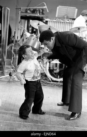 Muhammad Ali la Pop star. World Heavyweight Boxing champion Muhammad Ali è la stella della carità spettacolo di varietà in aiuto di ex e British Empire heavyweight champion Joe Erskine presso il Rainbow Theatre, Finsbury Park. La nostra immagine mostra: star del film Star Wars dwarf Kenny Baker lo sbarco di un buon punch sulle ali del naso. Muhammad Ali e Kenny Baker durante la loro lotta di scena. Gennaio 1979 Foto Stock