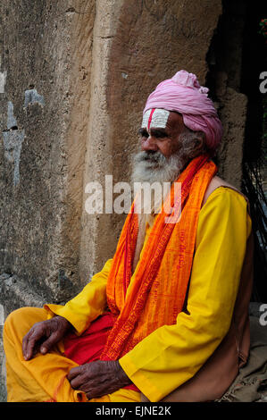 Indian Vishnu devoto Sadhu Uomo Santo seduto su una parete a Royal cenotaphs Orchha Madhya Pradesh India Foto Stock