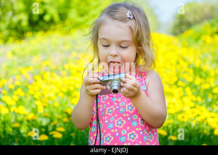 Bambina di scattare le foto su un prato Foto Stock