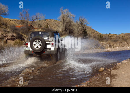 Jeep creazione di azionamento a spruzzo attraverso acqua lungo Alamosa Creek Monticello Box Canyon New Mexico USA Foto Stock