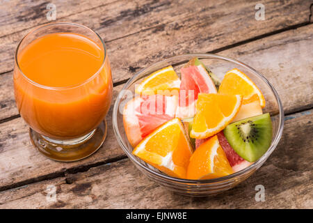 Macedonia di frutta fresca con vetro di Apple e di succo di carota sul vecchio tavolo in legno. Alimenti Eco vitamine sfondo Foto Stock